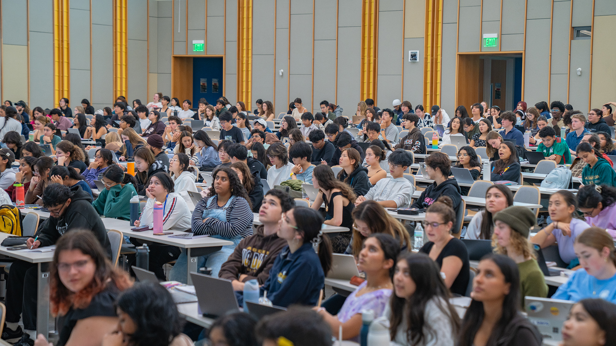Large group of students seated in lecture hall listening during an introductory biology class