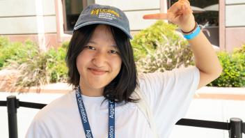 A student wearing a CBS cap and smiling