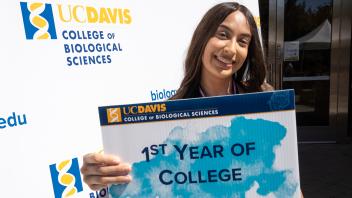 A student holding a first year of college sign