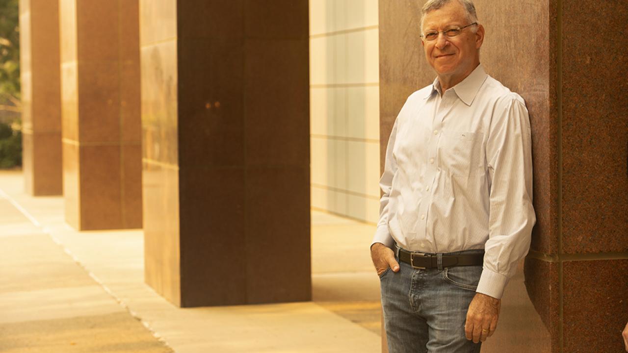 Harris Lewin stands outdoors against cement structure