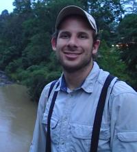 A person with a baseball cap standing outside