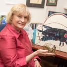 Ann Hedrick holds up a cricket statue in her office. David Slipher/UC Davis