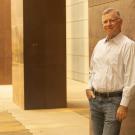 Harris Lewin stands outdoors against cement structure