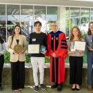 A group shot of award recipients with CBS dean in regalia