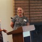 Two women standing near a podium with microphone