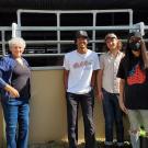 Group of people standing next to a horse stall