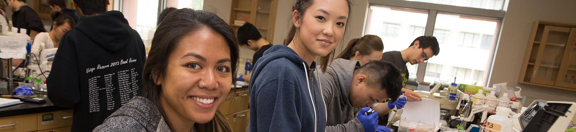 Group of male and female students in a lab classroom smiling